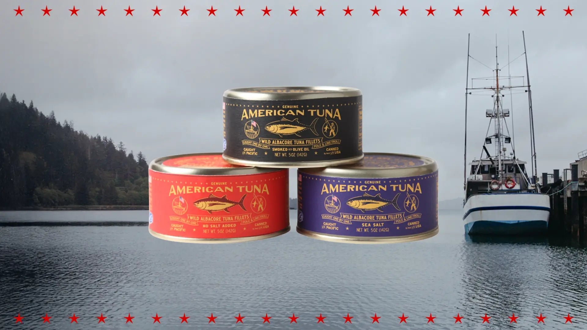Stack of American Tuna wild albacore tuna cans in different varieties, shown in front of a Pacific Northwest fishing harbor and vessel.