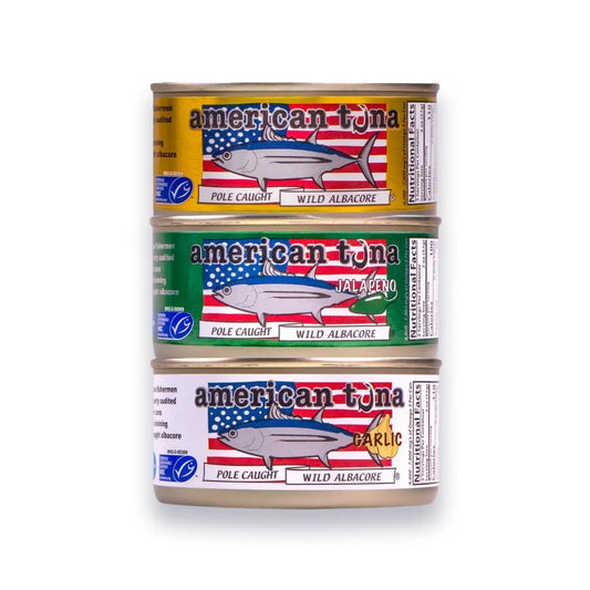 Three cans of American Tuna stacked on a white background